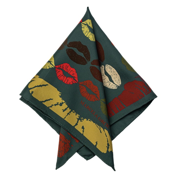 Mönstrad sidenscarf arrangerad som ett grafiskt produktstilleben.
